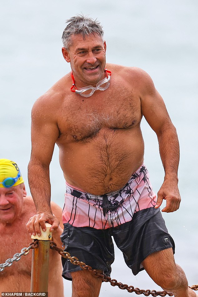 Jamie Durie Flexes Buff Biceps During Ocean Swim with Friends
This version maintains the key details (name, action, context, companions) while streamlining phrasing for conciseness.